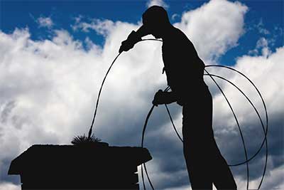 Chimney service Monmouth County performing chimney sweep on roof