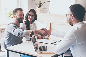 Real estate agent shaking hands with clients after they find their dream home among homes for sale in Monmouth County NJ